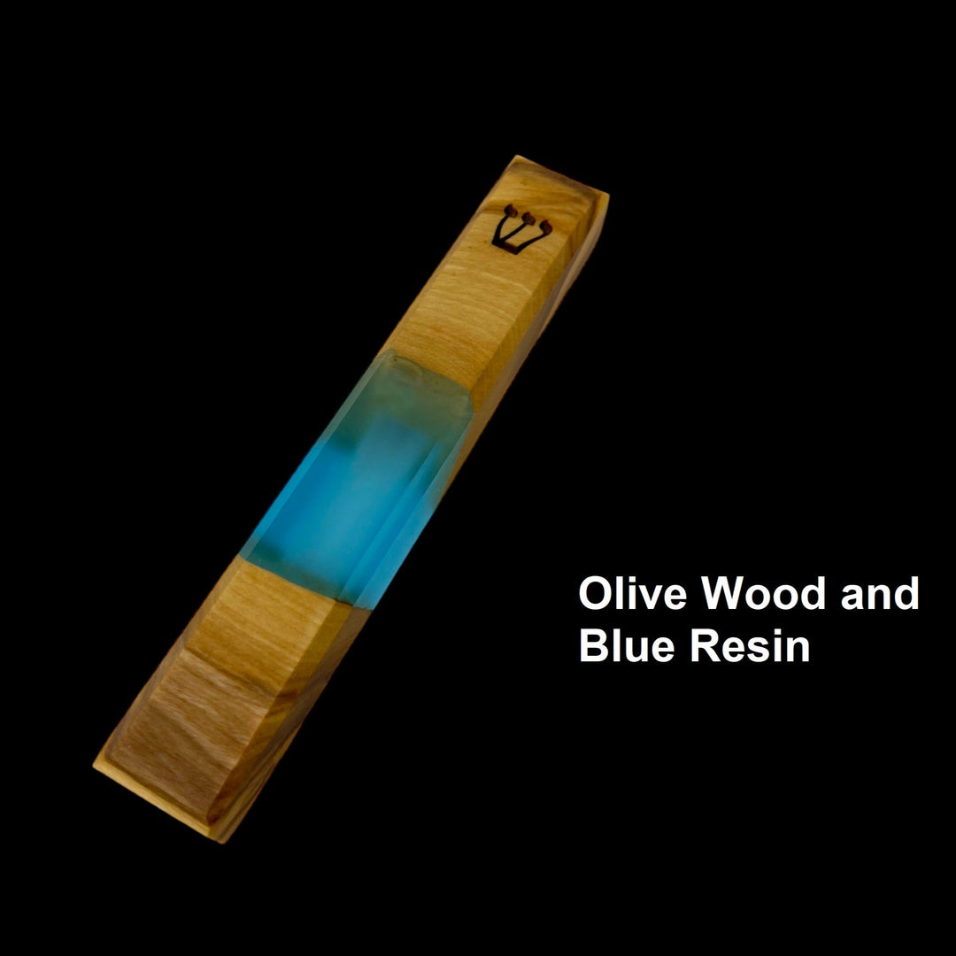 Engraved handmade olive wood and blue resin mezuzah on black background