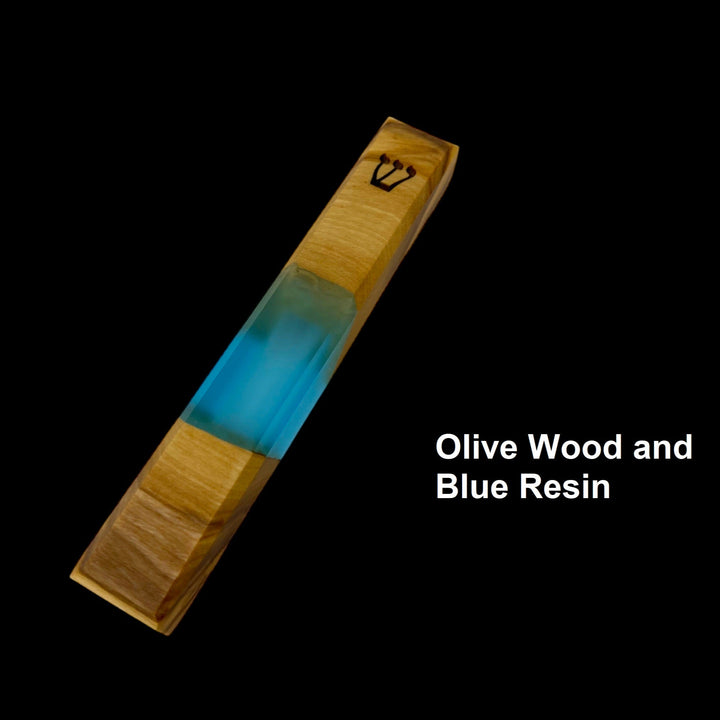 Engraved handmade olive wood and blue resin mezuzah on black background