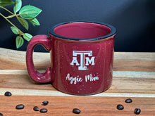 Load image into Gallery viewer, Maroon with white specs and black specs camping mug, with Texas A&amp;M Logo and Aggie Mom deep etched onto the stoneware mug
