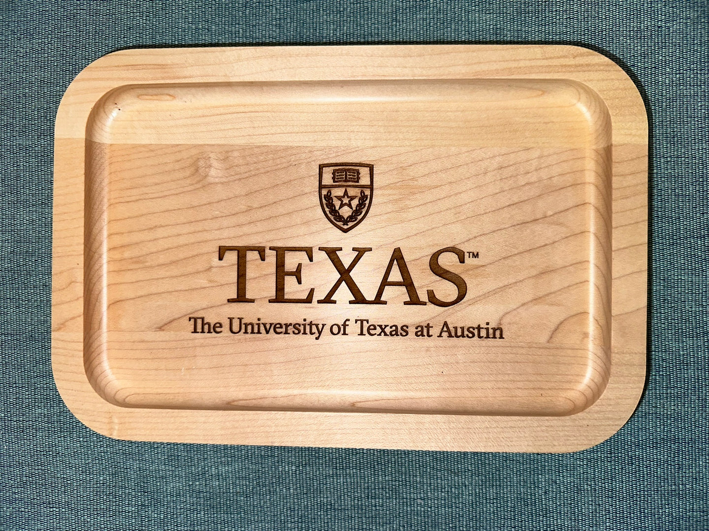 University of Texas at Austin Maple Wood Ring Tray with University Crest laying on black surface