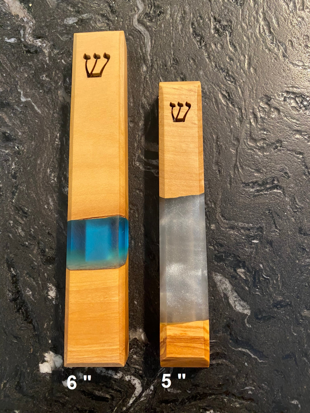 6" mezuzah and 5" mezuzah lying side by side to show size differences